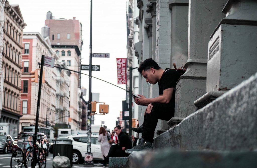 Man sitting on stoop in big city