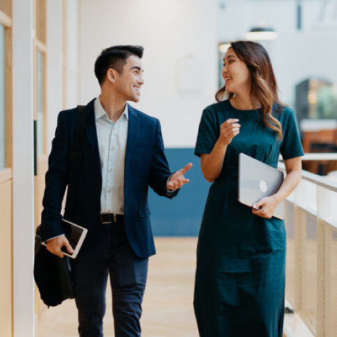 Two professionals walking and talking together.